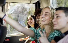 Teens riding the bus and having fun together on a outing for tween and teens