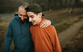 dad and teen son on a walk outside