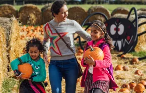 Mom and two daughters picking pumpkins at a pumpkin patch near Seattle