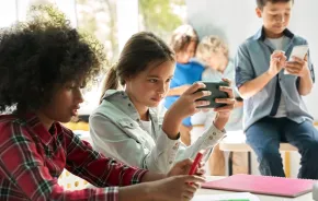 Kids using their cell phones in the classroom at school