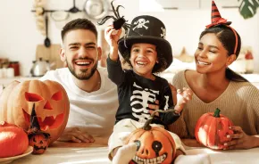 Family sitting together on Halloween with pumpkins and decorations