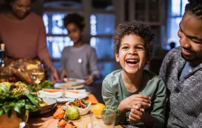 Kid at a Thanksgiving table with his family