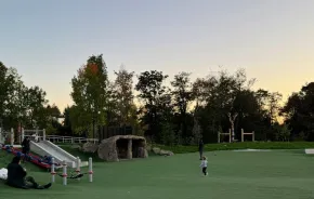 Young girl running in open space at Pathways Park, a lighted Seattle playground