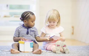 two toddlers sharing toys