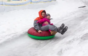 Dad and kid in a snow tube having winter fun near Seattle