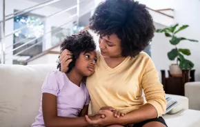 mom comforting daughter on the couch after a political election