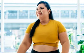 hopeful woman looks ahead to the new year in a happy yellow top