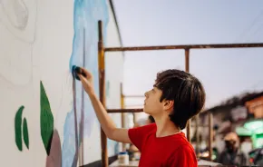 creative tween artist painting a mural