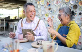 Couple laughing and making pottery together