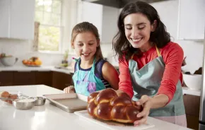 child and mom making challah together