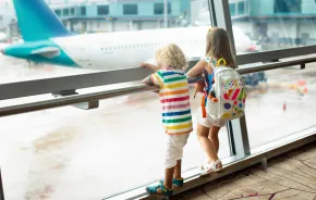 two kids looking out a window at an airplane SEA airport