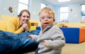 Young boy with glasses smiling and having fun at a sensory friendly play area