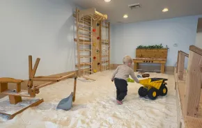 young boy pushing a truck in the lavender-infused sand pit at Wildflower Play Studio in Enumclaw