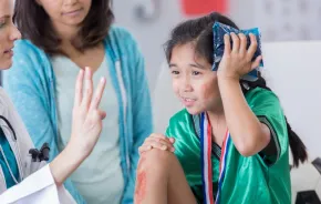 young girl with an ice pack on her head hurt while playing soccer