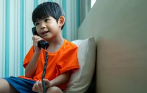 young boy talking on a landline phone