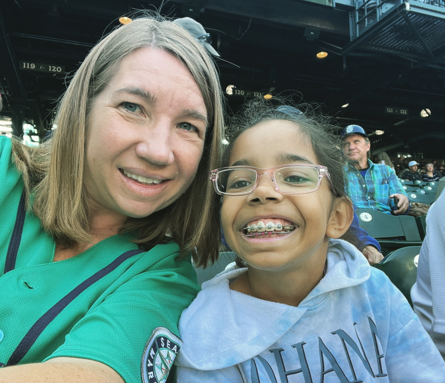 Mother and daughter smiling at a Mariner's baseball game