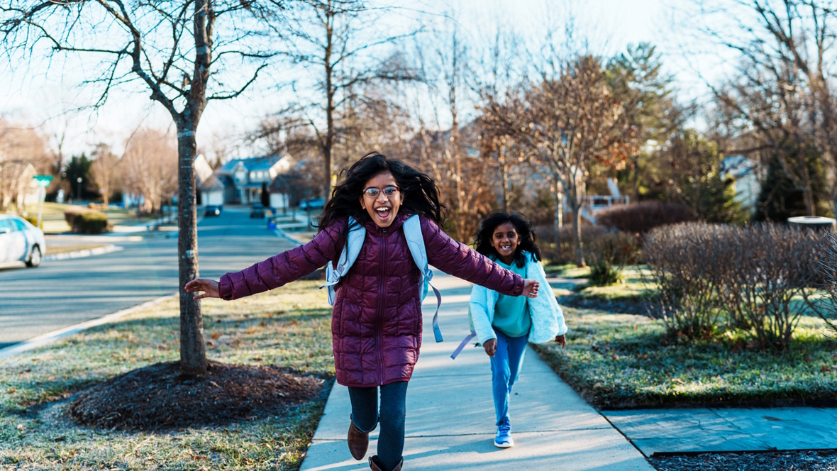 girls running down the street happy to be coming home
